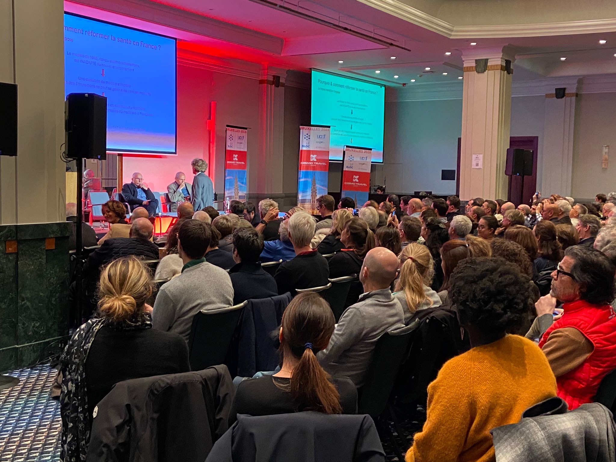 Konferenzsaal der Operation Brüssel 2026 mit Bannern von Kosmo Travel Groups auf der Bühne